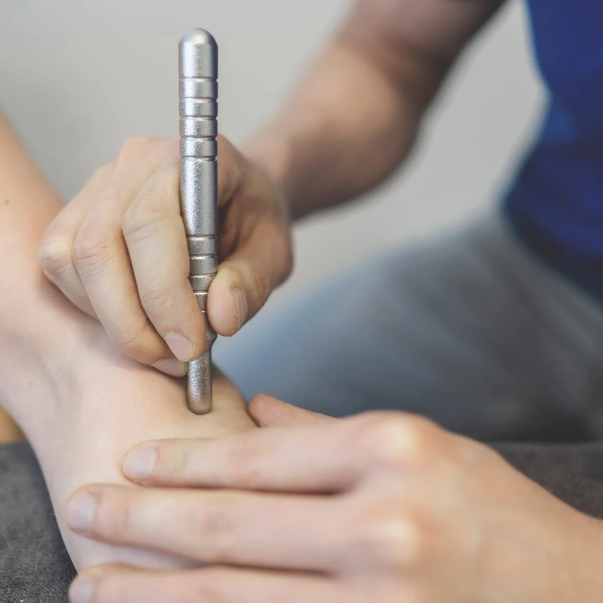Therapeut behandelt de voet van een patiënt met een fascia-tool