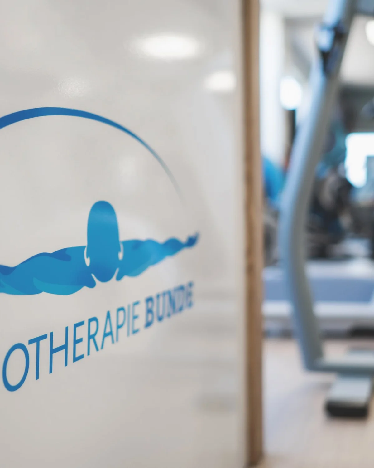 Logo van Fysiotherapie Bunde op de wand bij de oefenzaal